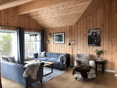 a living room with a couch and a table and chairs at 12 person holiday home in Skare-By Traum in Skare