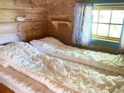 a bedroom with two beds in a log cabin at 4 person holiday home in Bryggja-By Traum in Bryggja