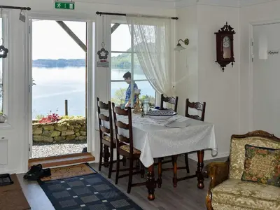 a dining room with a table and a view of the water at 6 person holiday home in Onarheim in Onarheim