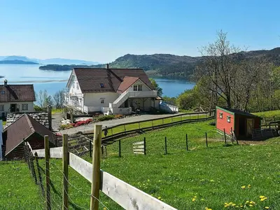 a house on the side of a hill with a fence at 6 person holiday home in Onarheim in Onarheim