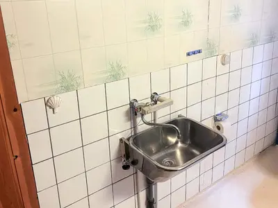 a stainless steel sink in a white tiled bathroom at 3 person holiday home in STRYN-By Traum in Stryn