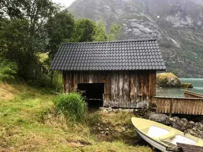 a small wooden building with a boat in front of it at 3 person holiday home in STRYN-By Traum in Stryn