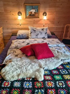 a bed with a blanket and pillows on it at Family Cabin With Firepit At Søndre Fjellstølen in Reinli