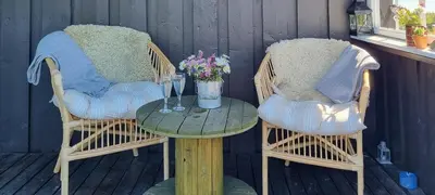 two chairs and a table with flowers on a porch at Family Cabin With Firepit At Søndre Fjellstølen in Reinli