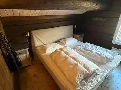 a large bed in a room with a wooden floor at Great cabin with gorgeous mountain views in Dagali