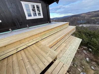 a wooden deck on the side of a house at Great cabin with gorgeous mountain views in Dagali