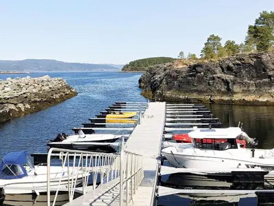 a row of boats docked at a dock in the water at 10 person holiday home in INDERØY-By Traum in Kjerkenesvåg