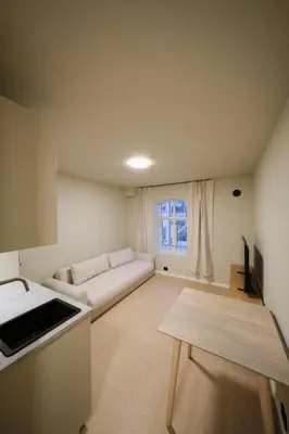 a living room with a couch and a table at Cozy and practical studio in the city center in Ålesund