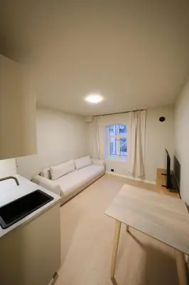 a living room with a couch and a table at Cozy and practical studio in the city center in Ålesund