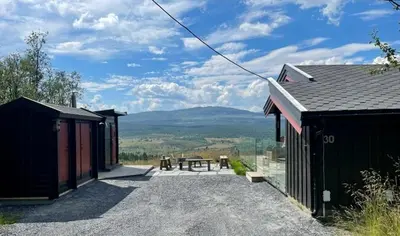 a house with a patio with a view of the mountains at Mountain Cabin With Panoramic Views In Brakastølen in Ron