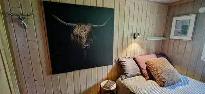 a painting of a bull on the wall of a bedroom at Mountain Cabin With Panoramic Views In Brakastølen in Ron