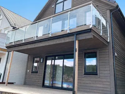 a house with glass doors and a balcony at 8 person holiday home in Urangsvåg in Ervik
