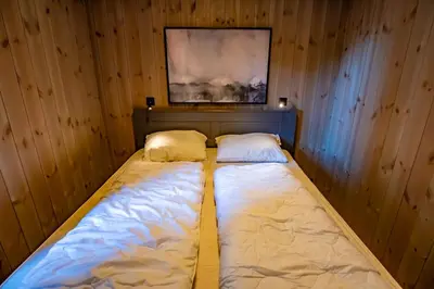 a bed in a wooden room with two pillows at Trysiltunet 10B in Trysil