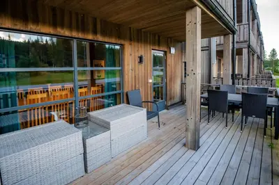 a wooden deck with a table and chairs on it at Trysiltunet 10B in Trysil