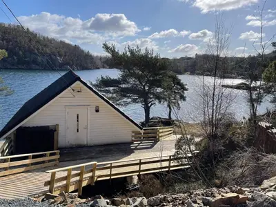 a small building on a dock next to a lake at 6 person holiday home in Rubbestadneset in Rubbestadneset