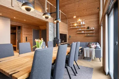 a dining room with a wooden table and chairs at Panoramahytte med fjellutsikt in Sogndal