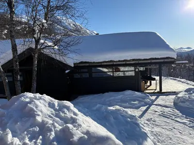 a house covered in snow with a pile of snow at Cosy cabin in Hemsedal with ski in-ski out to Solheisen in Hemsedal