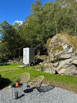 a table and two chairs and a trailer in a yard at Vollsnes Glamping in Stryn