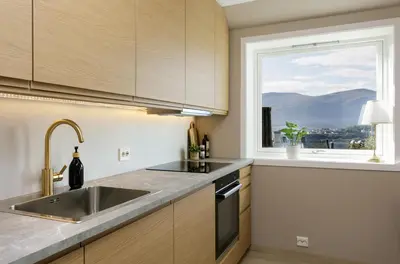a kitchen with a sink and a window at Fjord Vista - Top floor apartment in Ålesund in Ålesund