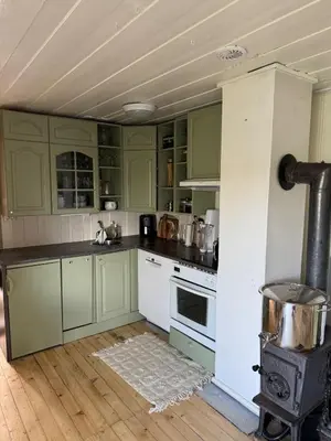 a kitchen with green cabinets and a stove at Idyllic cottage with a view, close to Gardermoen Airport in Hurdal