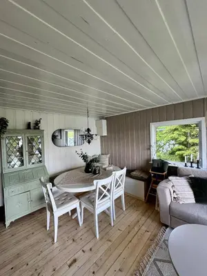 a living room with a table and chairs and a couch at Idyllic cottage with a view, close to Gardermoen Airport in Hurdal
