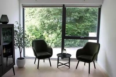 two chairs and a table in front of a window at Moderne hus - sentralt, rolig med gratis parkering in Bergen