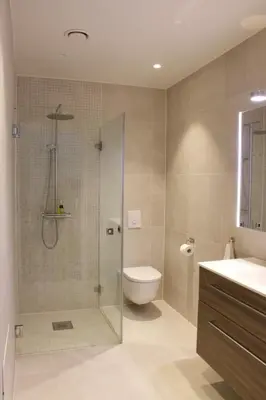 a bathroom with a shower and a toilet and a sink at Moderne hus - sentralt, rolig med gratis parkering in Bergen