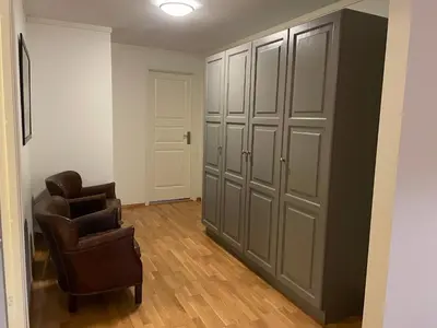 a room with two chairs and a closet at Sentral Og Moderne Leilighet Med Heis Og Garasje in Beitostøl