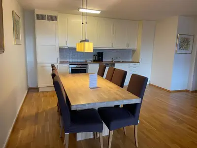 a kitchen with a wooden table and chairs at Sentral Og Moderne Leilighet Med Heis Og Garasje in Beitostøl