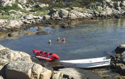 a group of people swimming in a river with a boat at Nice Home In Sauøya With House Sea View