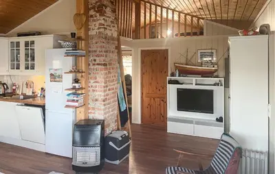 a kitchen with white cabinets and a brick wall at Nice Home In Sauøya With House Sea View