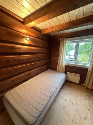 a bed in a log cabin with a window at Peaceful cabin with secluded location in Ål