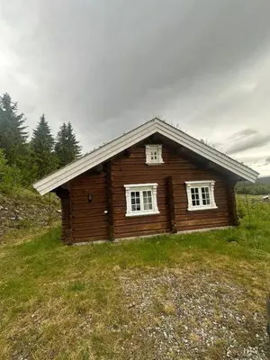 a log cabin with two windows in a field at Peaceful cabin with secluded location in Ål