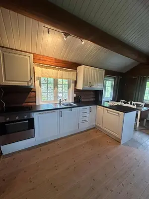a kitchen with white cabinets and black counter tops at Peaceful cabin with secluded location in Ål