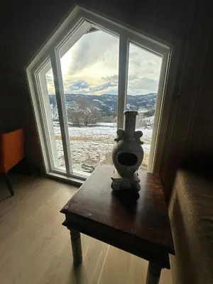 a vase sitting on a table in front of a window at Cozy little cottage for rent in Oppheim in Ål