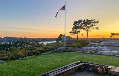 an american flag on a flag pole in a field at Beautiful Home In Fitjar With House Sea View in Fitjar