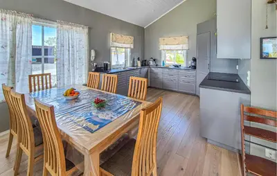 a kitchen and dining room with a table and chairs at Beautiful Home In Fitjar With House Sea View in Fitjar
