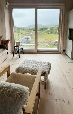 a living room with a large window and a couch at Architect-Designed Cabin With Views Of Sigdal in Eggedal