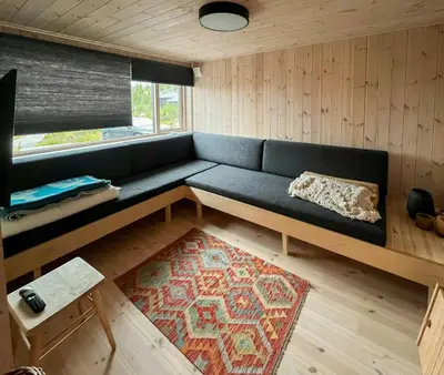 a living room with a blue couch and a rug at Architect-Designed Cabin With Views Of Sigdal in Eggedal