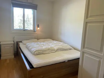 an unmade bed in a room with a window at Stor Leilighet Med 4 Soverom Og 2 Bad in Beitostøl