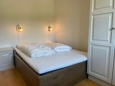 a bed in a room with two lights on it at Stor Leilighet Med 4 Soverom Og 2 Bad in Beitostøl