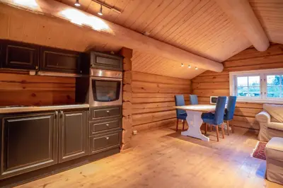 a kitchen and dining room with a table and chairs at Trysilfjellet Nord 901 stabur in Trysil