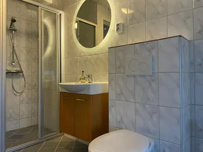 a bathroom with a toilet and a sink and a shower at Stor Og Moderne Leilighet I Sentrum in Beitostøl
