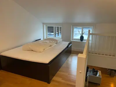 a large bed in a room with a staircase at Stor Og Moderne Leilighet I Sentrum in Beitostøl