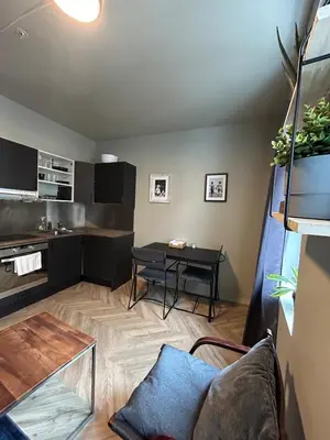 a living room with a table and a kitchen at Cozy place in the city center, Bergen! in Lii