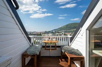 a balcony with a table and chairs with a view at Privat rom i koselig Bergenshus in Bergen