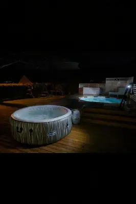 a large bath tub on a deck at night at Koselig ved Fjorden - Vangsnes in Vangsnes