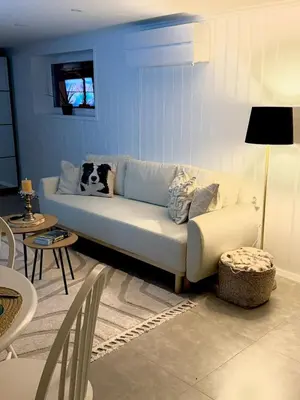 a living room with a white couch and a blue wall at Koselig ved Fjorden - Vangsnes in Vangsnes