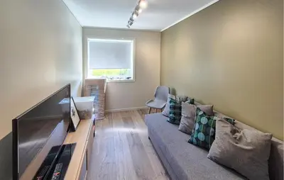 a living room with a couch and a television at Beautiful Home In Bjørøyhamn With House Sea View in Nord Bjørøy