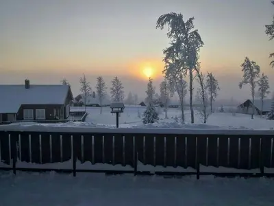 a snow covered yard with a house and the sunset at Mountain Gem With Ski In And Out At Golsfjellet in Gol